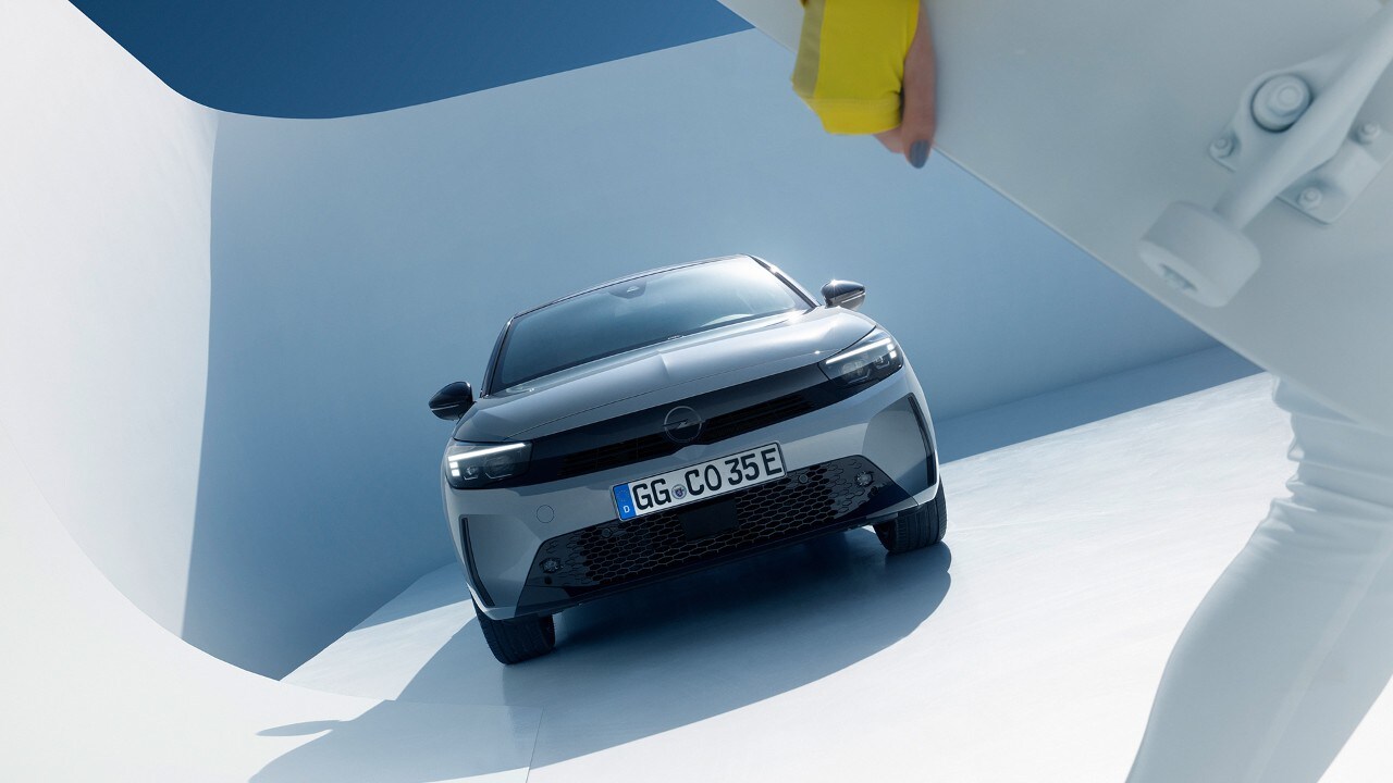 Vista frontal de un Opel Corsa Electric gris con aleaciones negras y techo